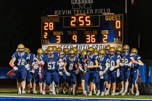 Scoreboard shows 2:55 remaining with players lined up on football field at night.