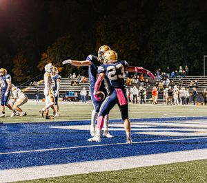 A sequence of cheerleading stunts shows a performer being launched into a backflip on a blue football field.
