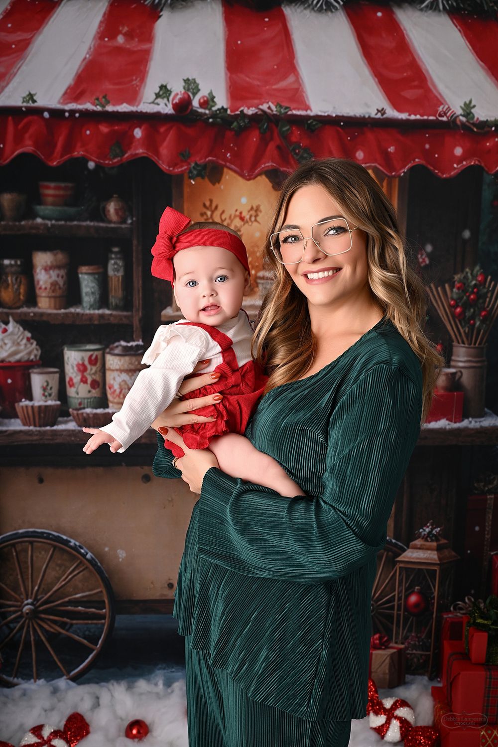 Festive portrait session featuring emerald green dress against red and white Christmas decorations.