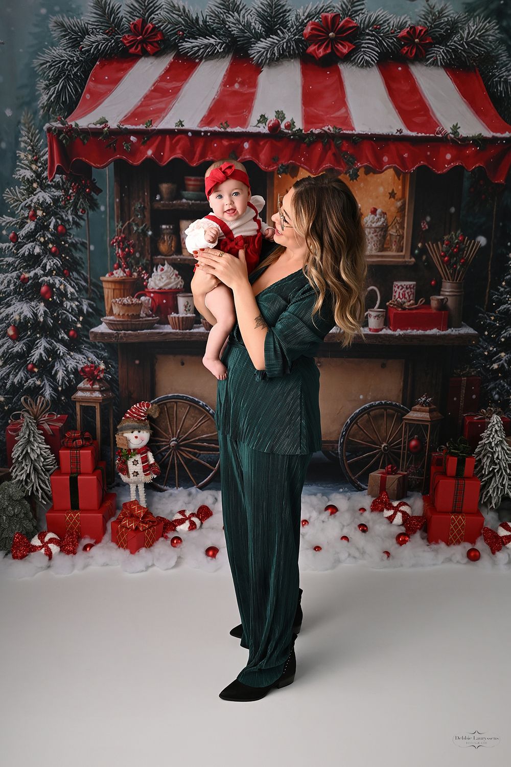 Full-length holiday portrait against Christmas shop display with snow and vintage decorations.