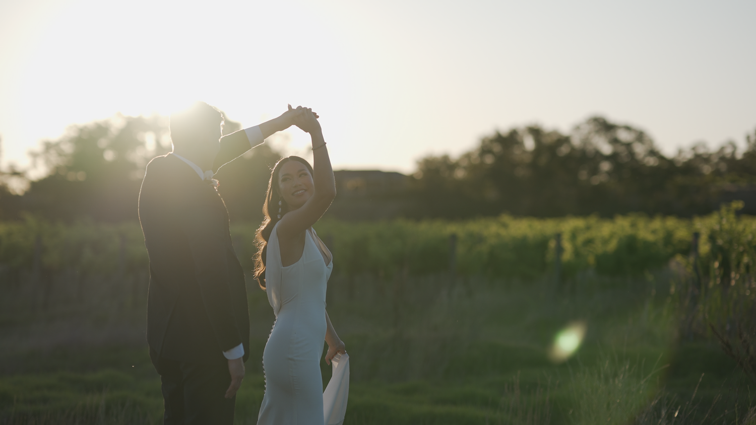 Romantic sunset photoshoot in a golden field with lens flare.
