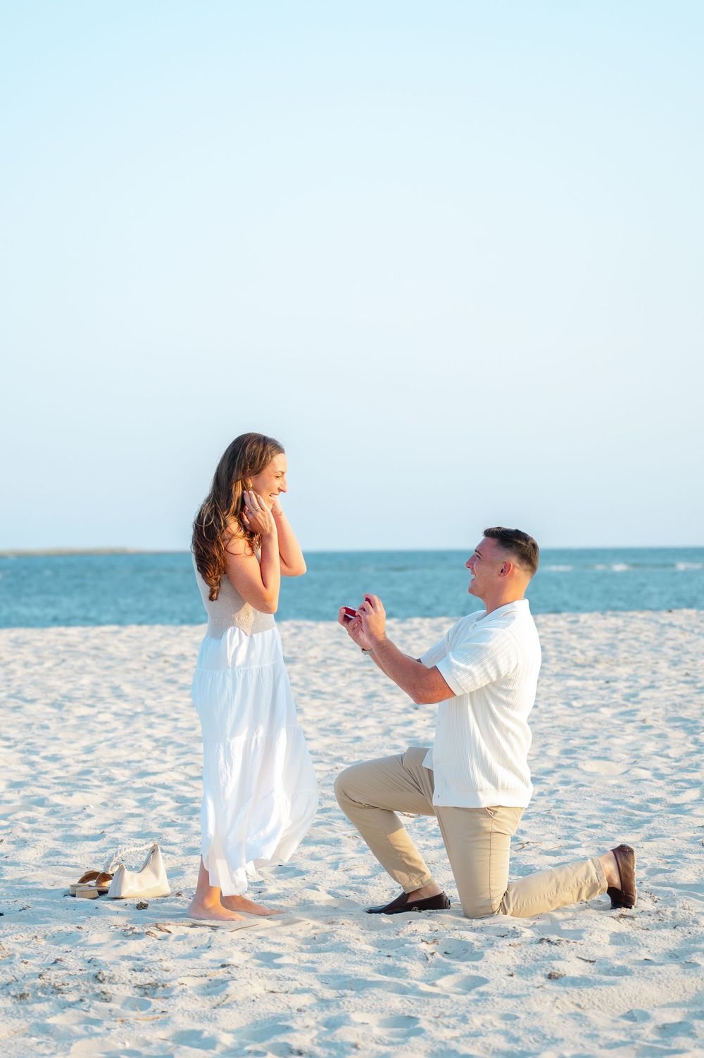 A romantic beach proposal on white sand by the ocean in Long Island captured by NY proposal photographer.