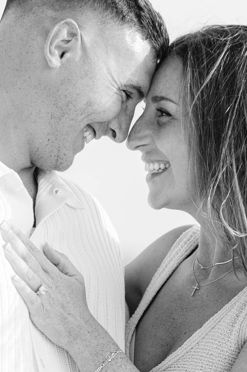 A romantic black and white close-up portrait of a couple sharing an intimate moment together after their engagement.