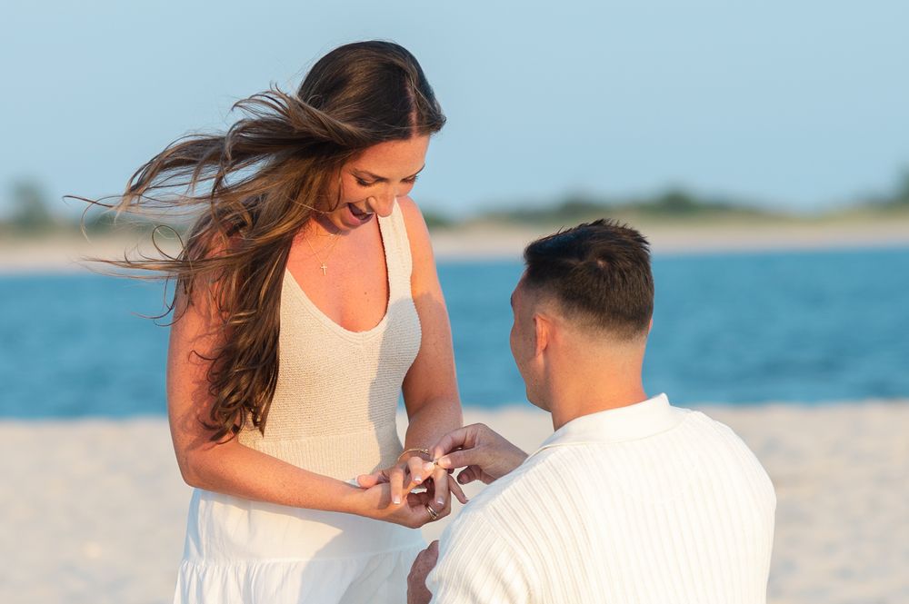 A man places a ring on a woman's finger after he proposes to her at Point Lookout in Lido Beach, NY.