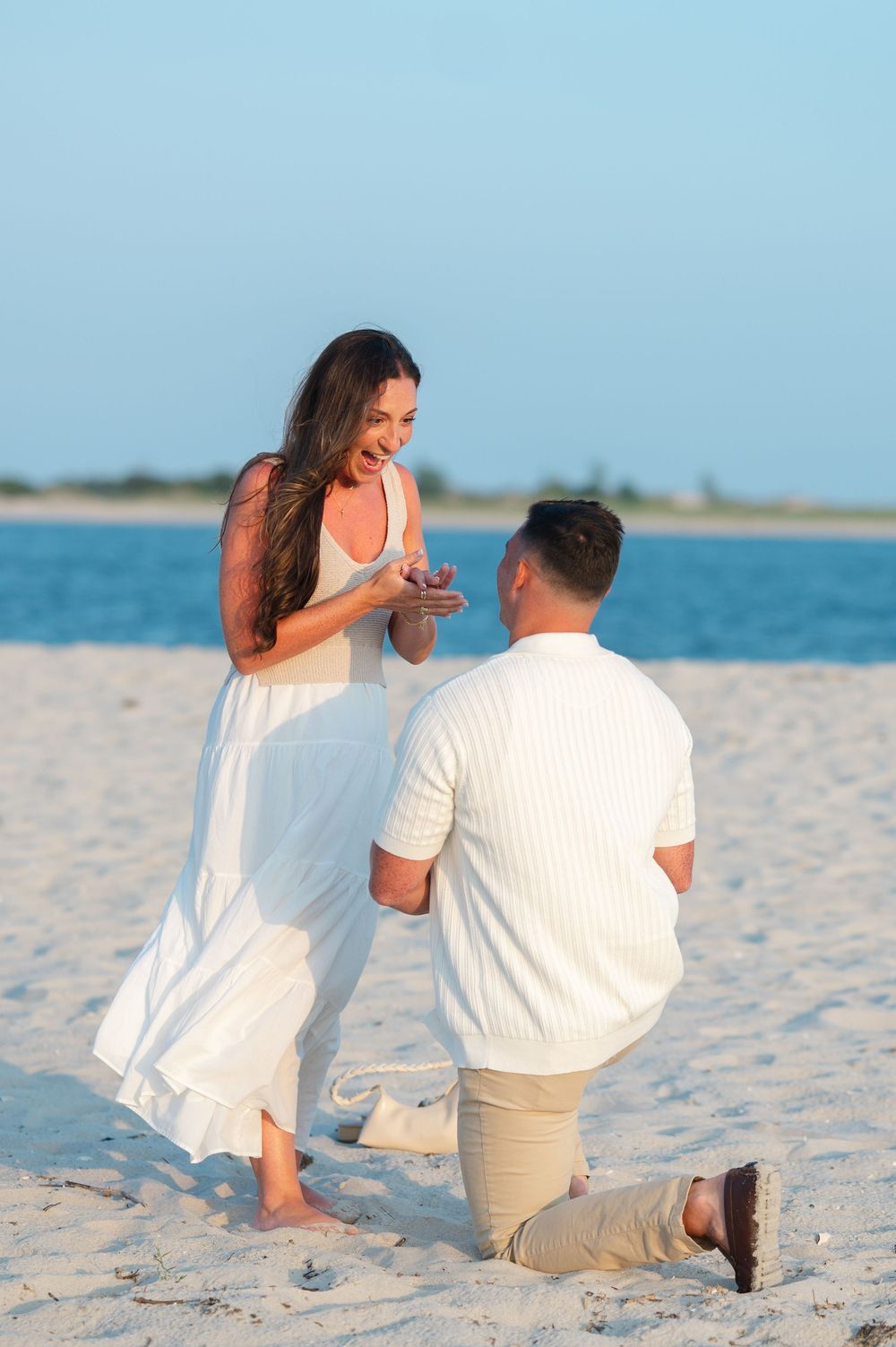 A surprise proposal unfolds in sequence on a pristine beach with the ocean as backdrop.