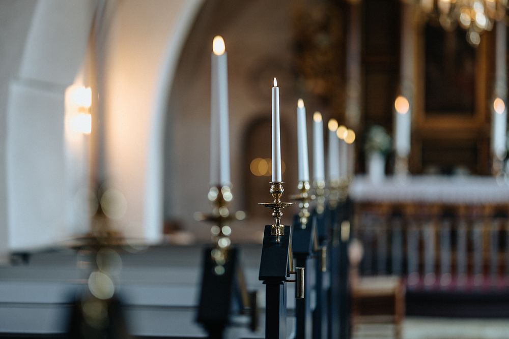 Elegant black candelabras with white candles line a formal table setting in a luxurious dining room.