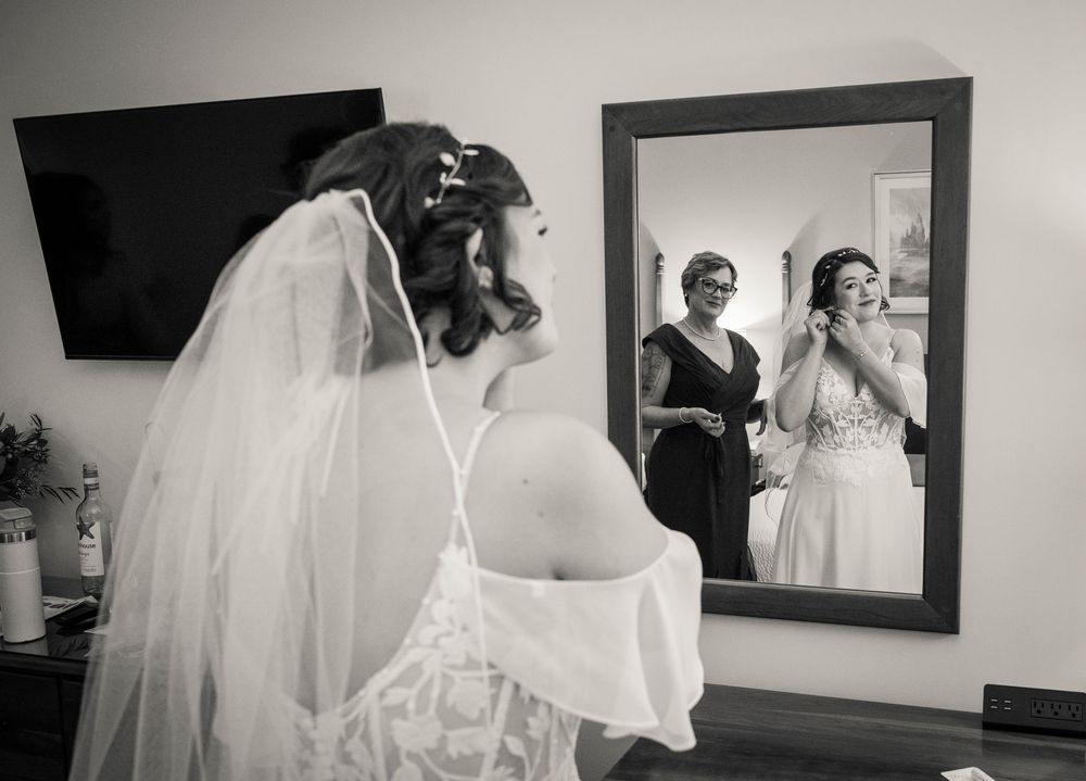 A series of black and white wedding preparation photos showing details of a bride's dress, veil and getting ready moments.