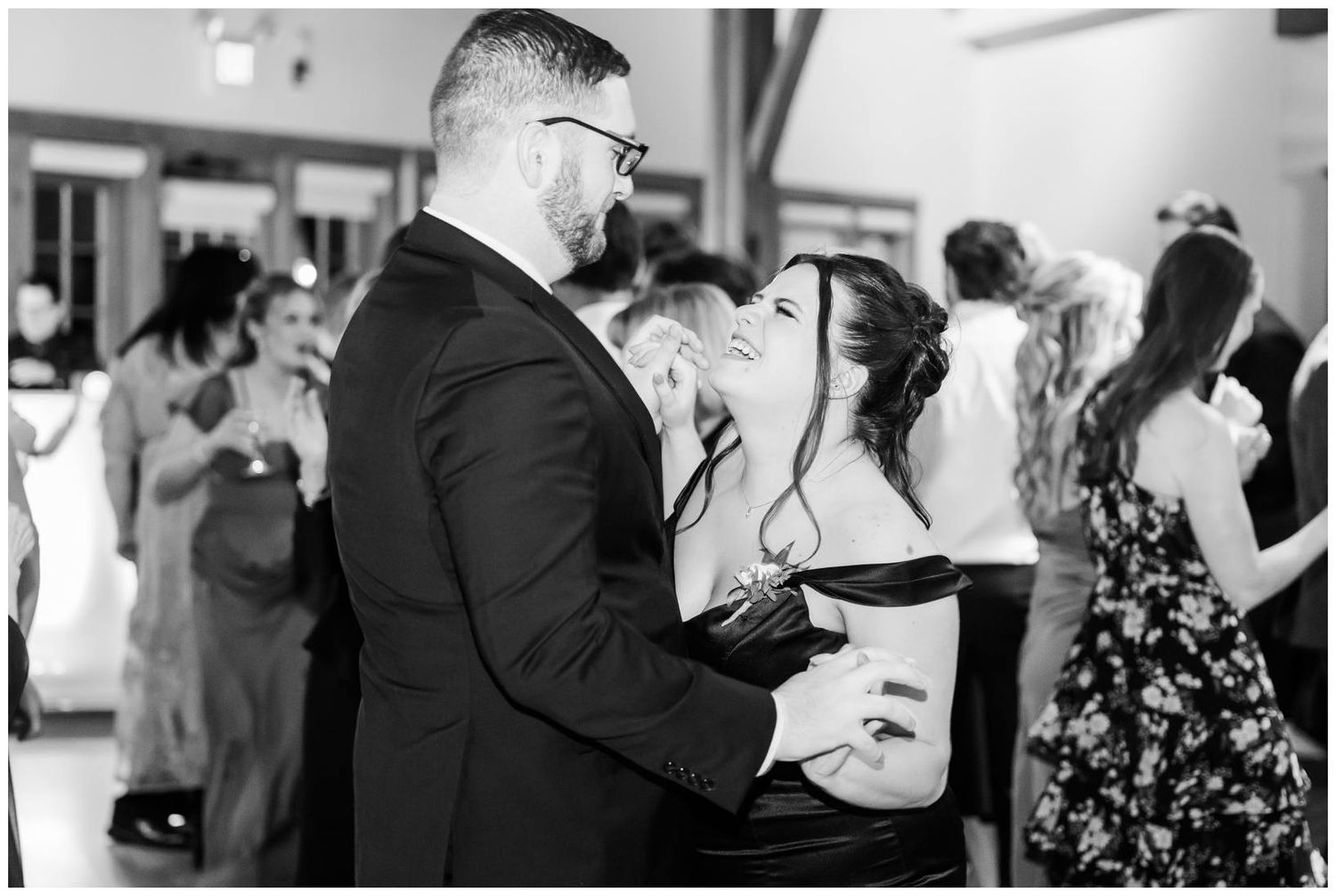 Black and white photo of a couple sharing an intimate dance moment at a wedding reception.