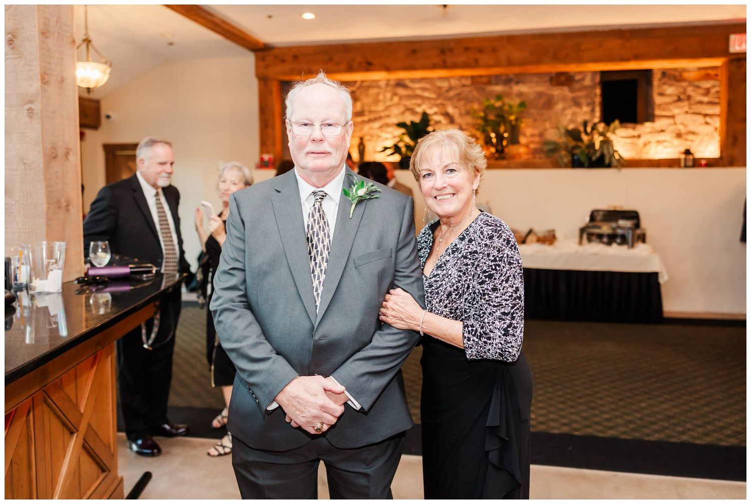 Wedding reception venue features exposed brick walls and elegant lighting in an indoor celebration space.