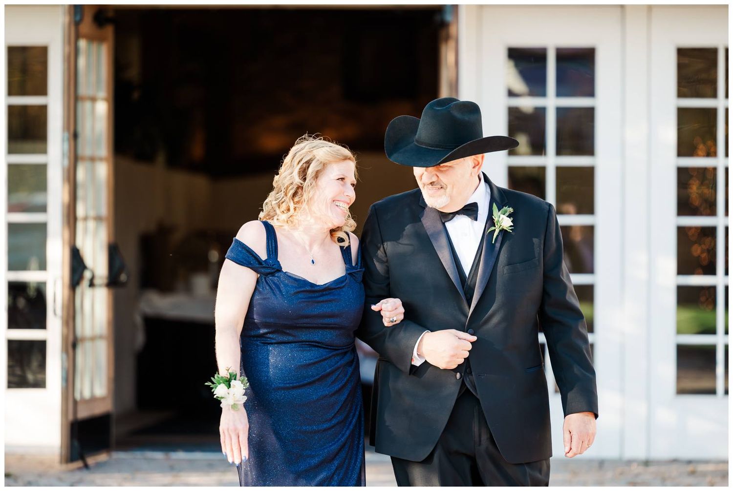 Wedding party members in navy blue and black formal attire walking together outdoors.