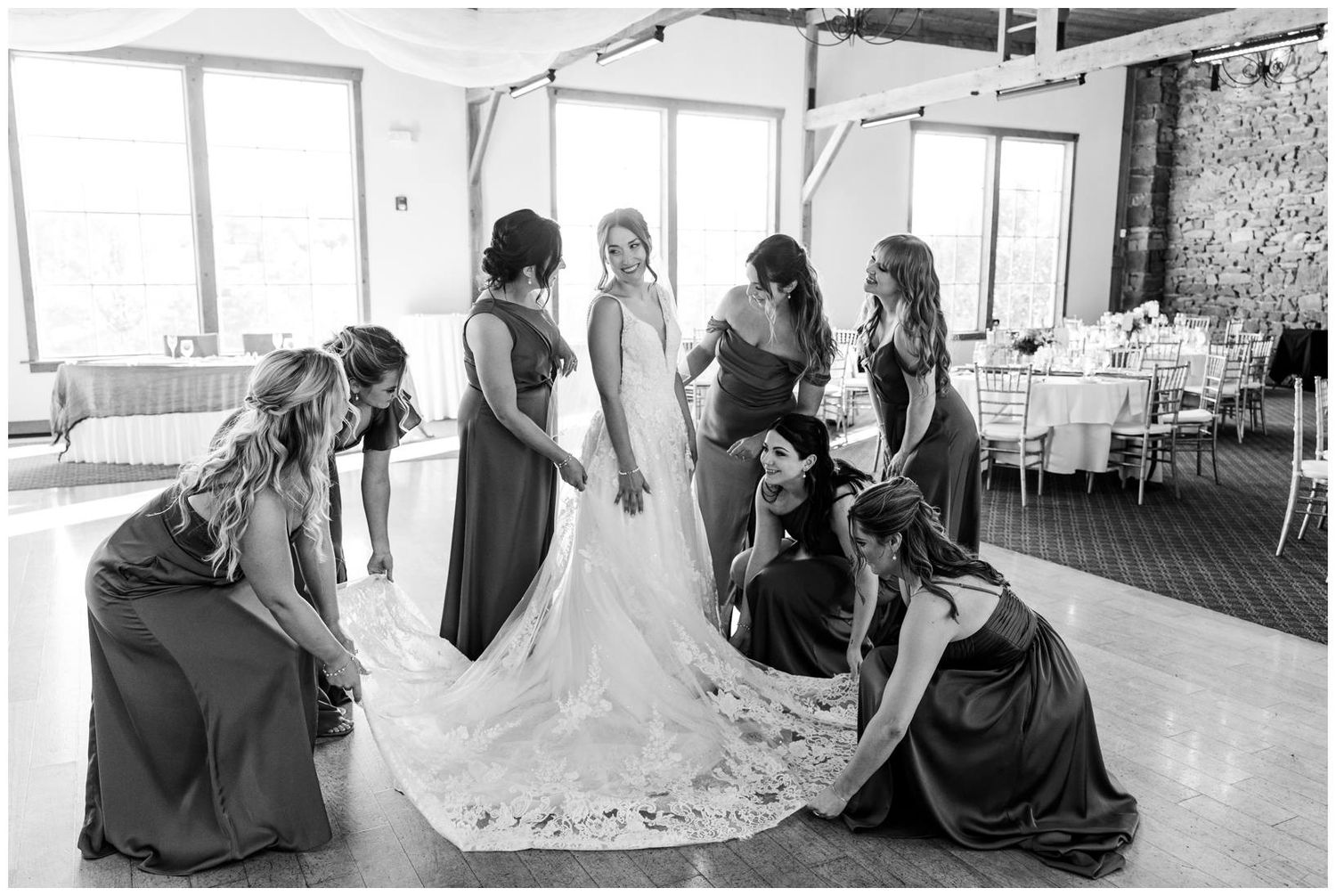 Wedding party gathered in a bright modern venue with floor to ceiling windows and natural light.