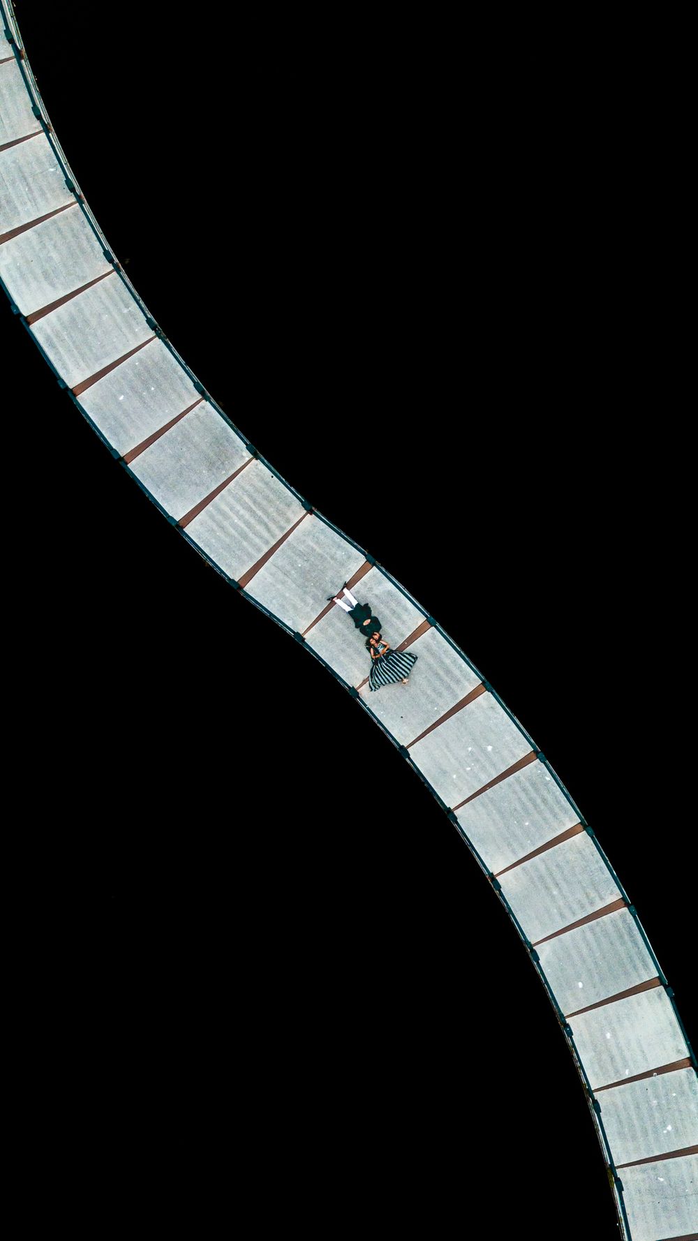 A sequence of black and white photographs showing a small insect crawling up a curved staircase made of paper.