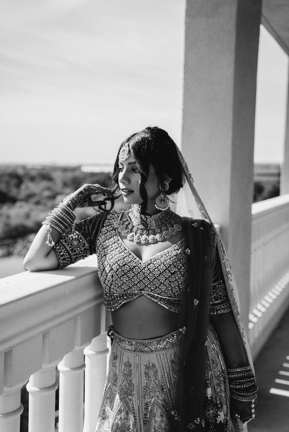 Black and white portrait series of a woman in traditional Indian attire on a porch with white columns.