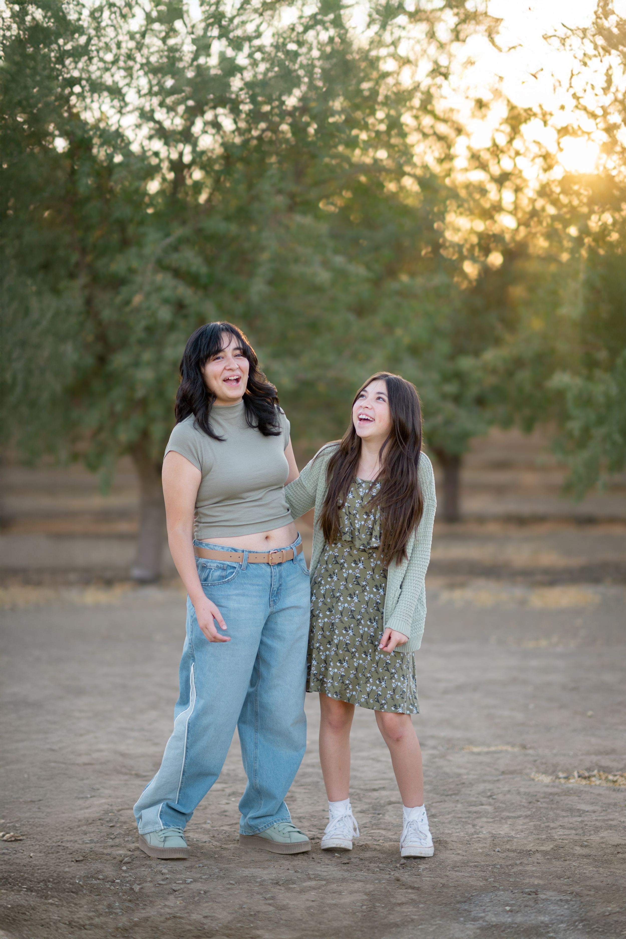 Two people share a joyful moment together outdoors during golden hour sunset in a natural setting.