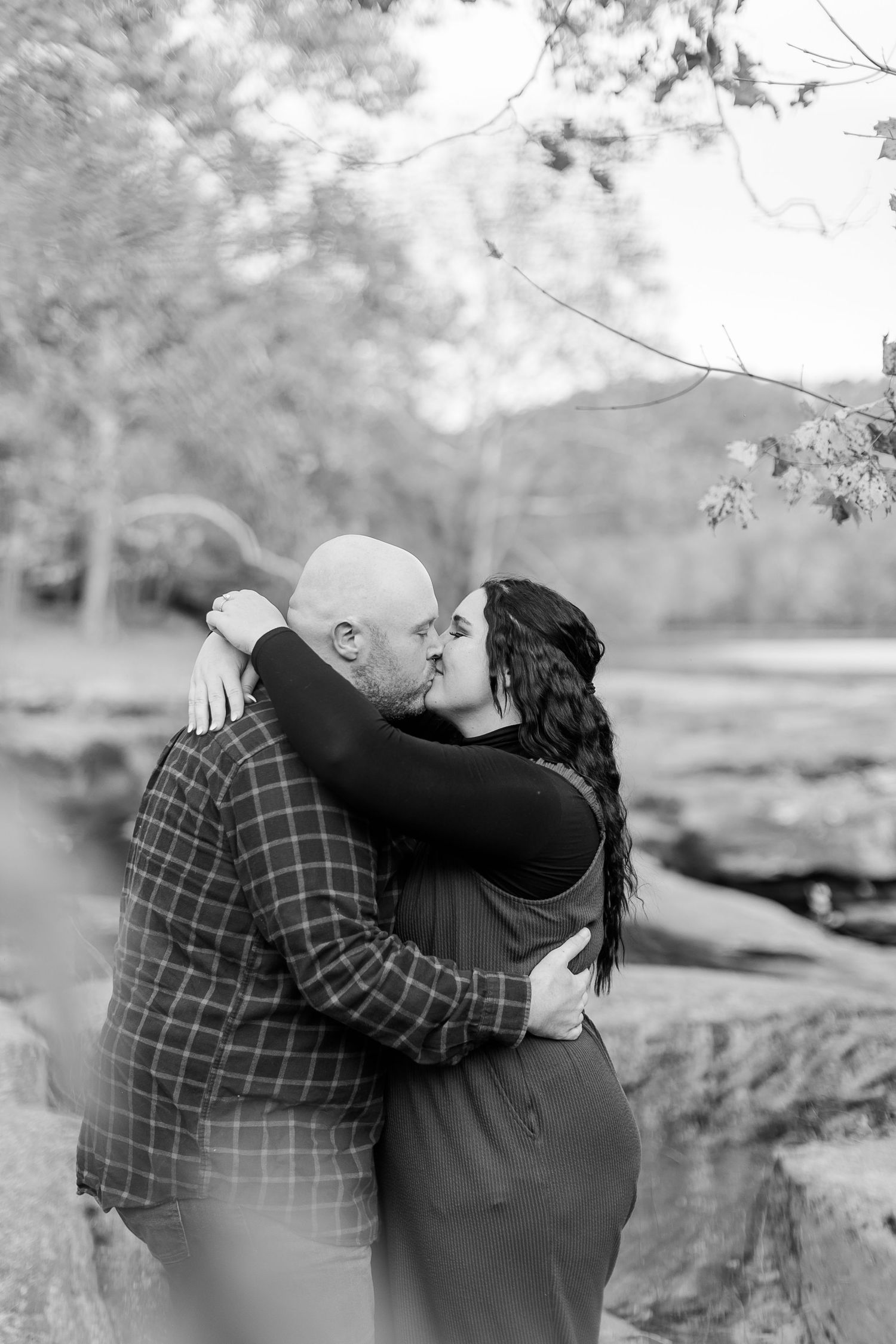 A romantic black and white photo sequence shows a couple embracing on a rocky outcrop in nature.