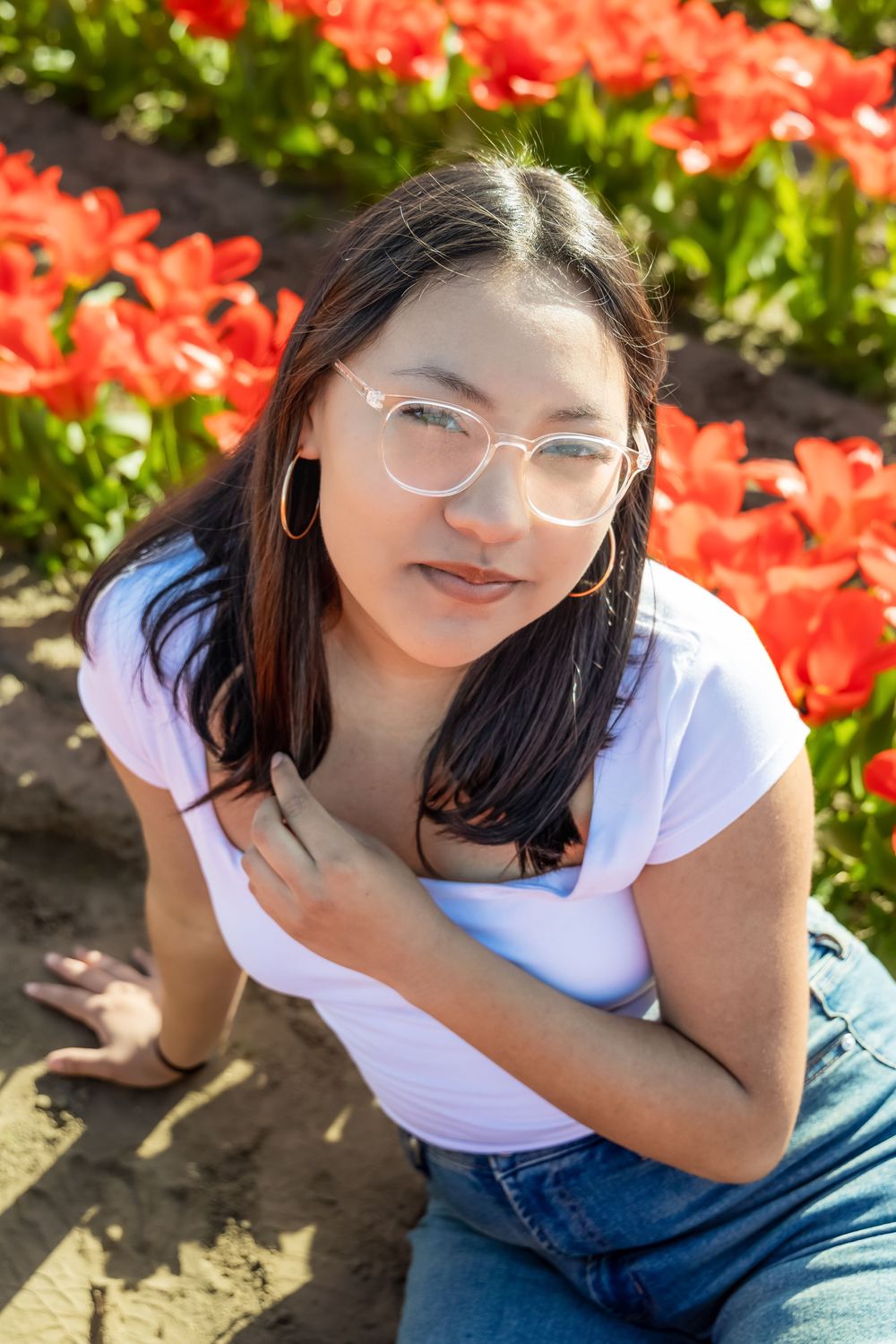 A series of outdoor portrait shots with vibrant red flowers and greenery in the background.