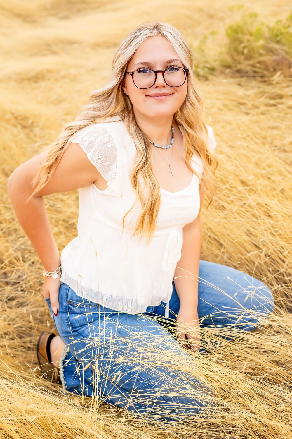 Portrait session in a golden wheat field with soft natural lighting and casual styling.