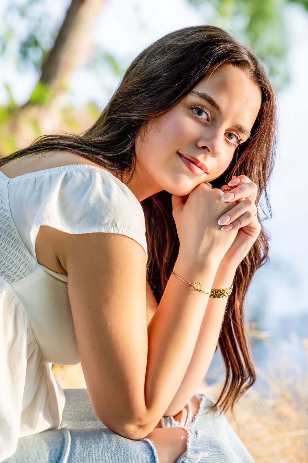 Outdoor portrait session with soft natural lighting and blurred foliage background.