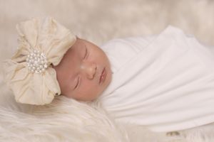 Newborn baby wrapped in neutral blanket during in-home studio session in San Diego