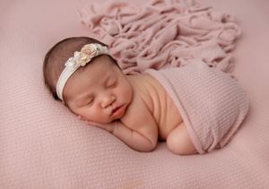Peaceful sleeping newborn photographed in cozy home studio setting