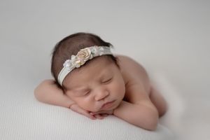 Peaceful sleeping newborn photographed in cozy home studio setting