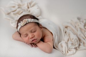Newborn baby wrapped in neutral blanket during in-home studio session in San Diego
