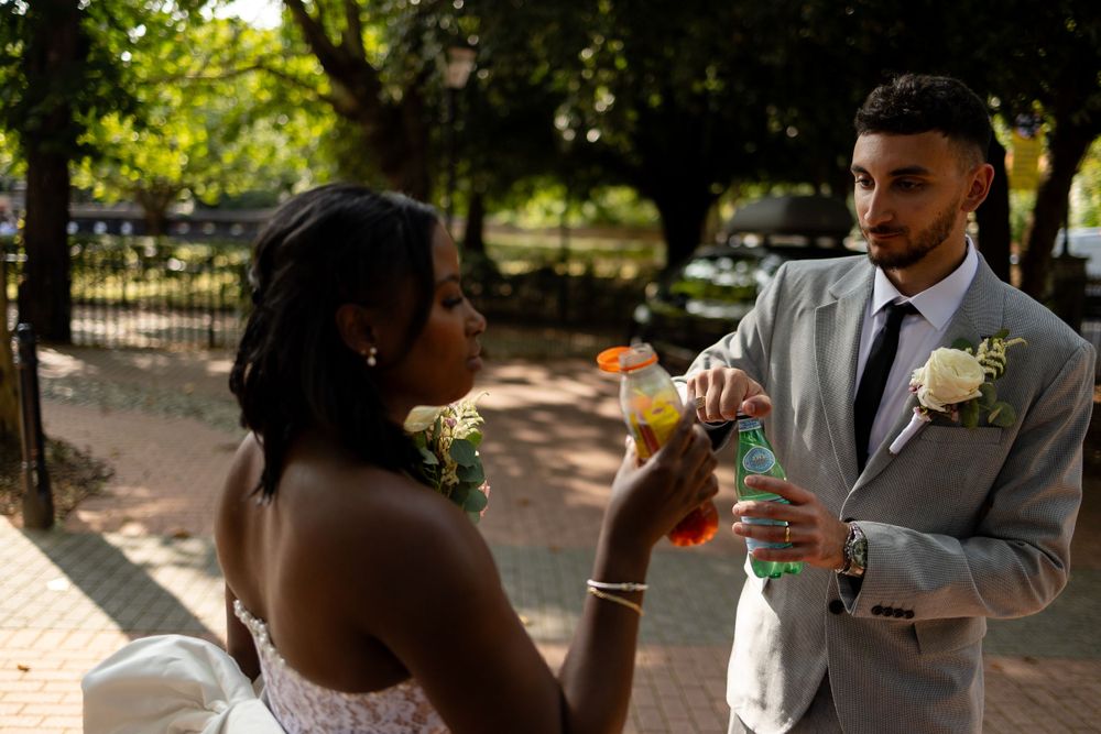 A sunny outdoor wedding portrait with cocktails and formal attire.