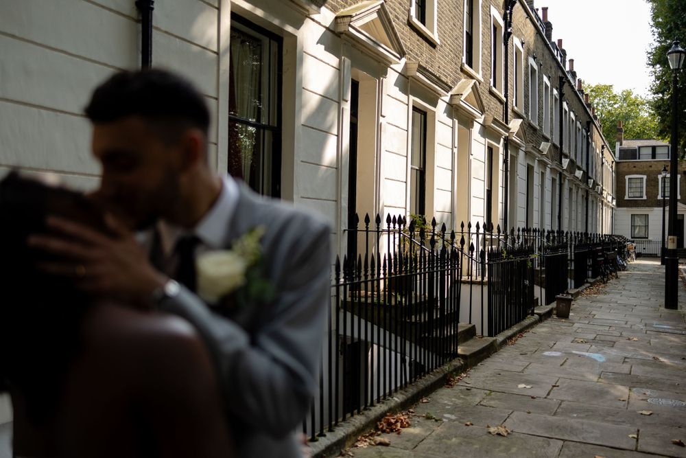 A romantic wedding photo captured against an urban townhouse backdrop.