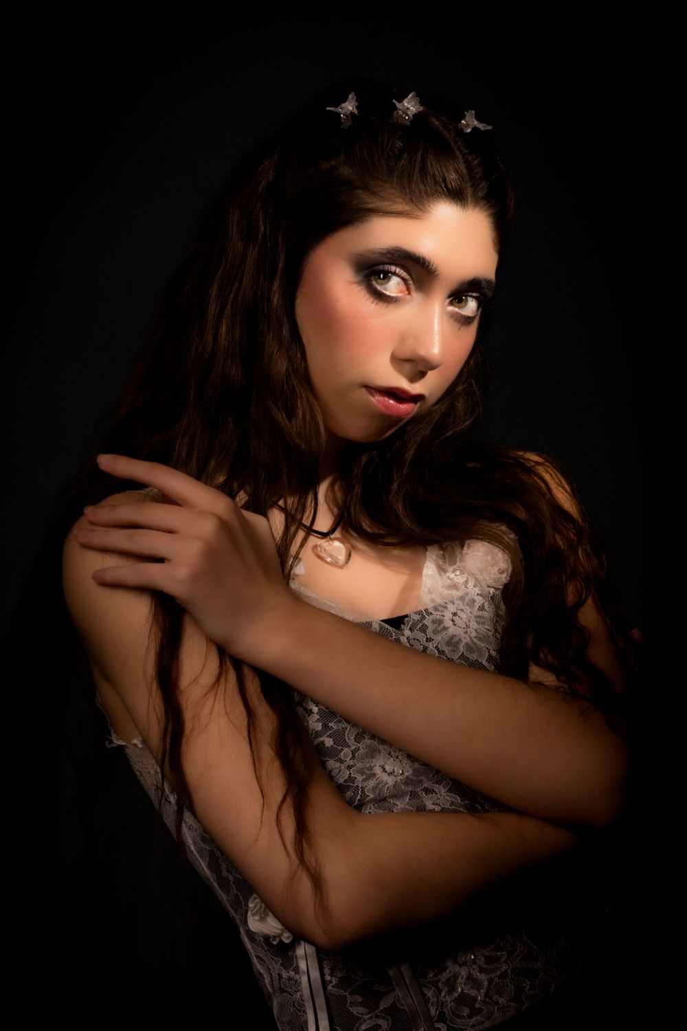 Artistic portrait series showing dramatic poses against dark background with moody lighting and textured clothing.