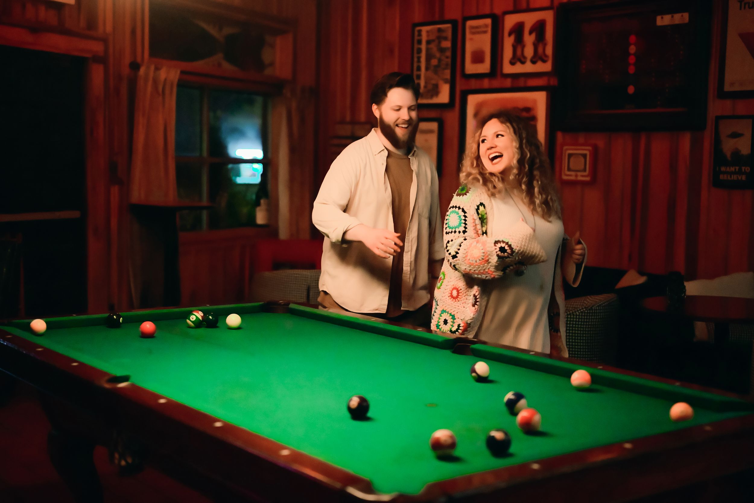People play pool at a dimly lit bar with red walls and green felt tables in a sequence of action shots.