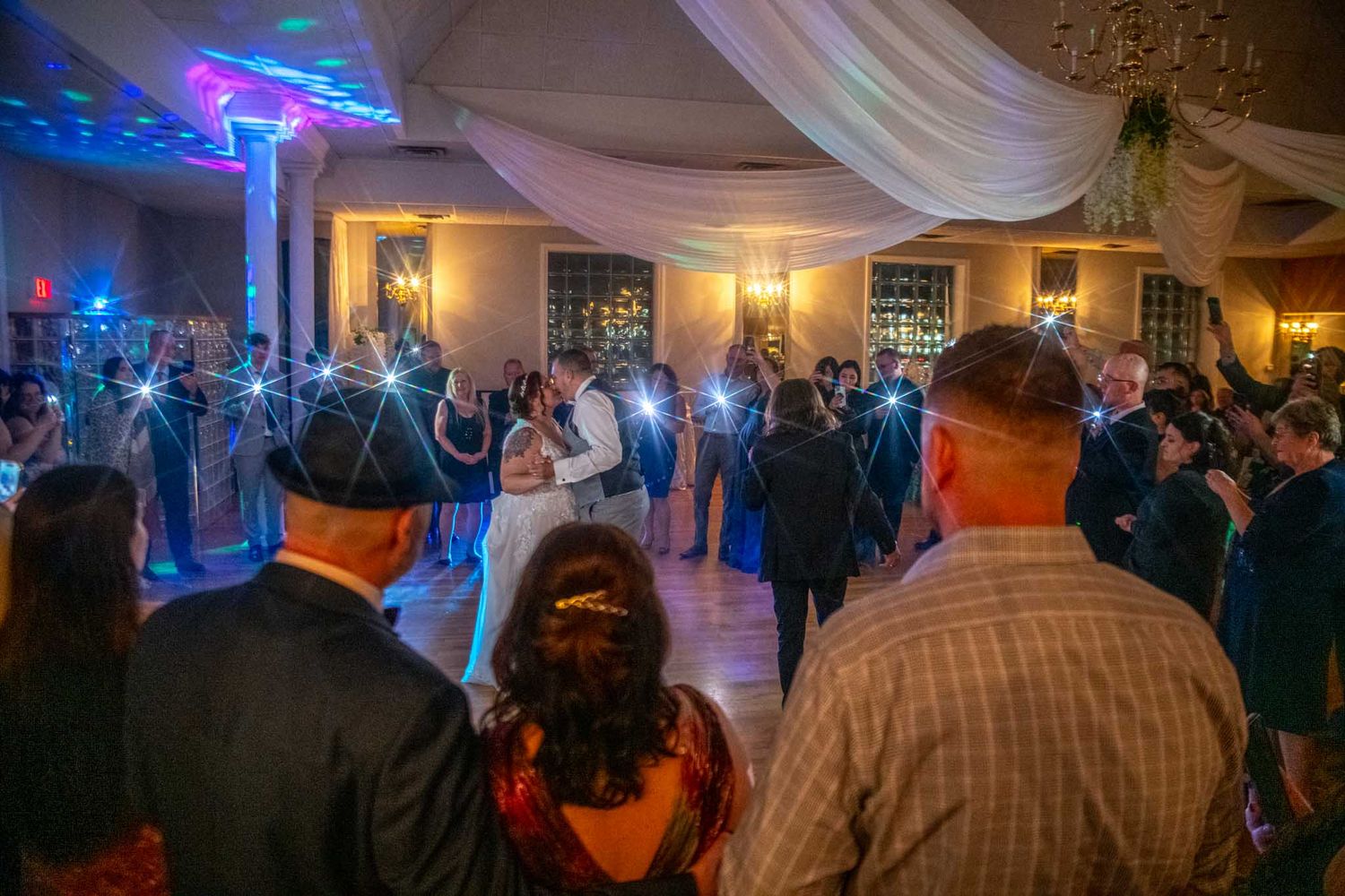 Taken in Rockstar Music Hall in Windsor, Ontario. Wedding couple in the dance floor filled with guests enjoying music in an elegant venue.