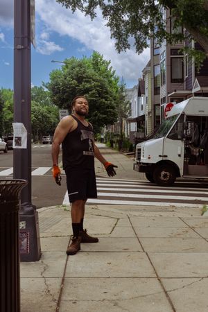 Person stretching on a city sidewalk during a sunny summer day.