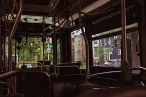 Interior view of an empty public transit bus with rows of seats and windows.