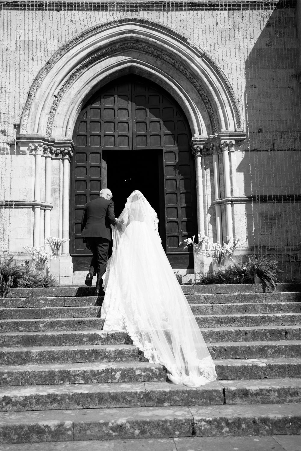 A series of black and white photos showing a bride in a white gown descending stone church steps.