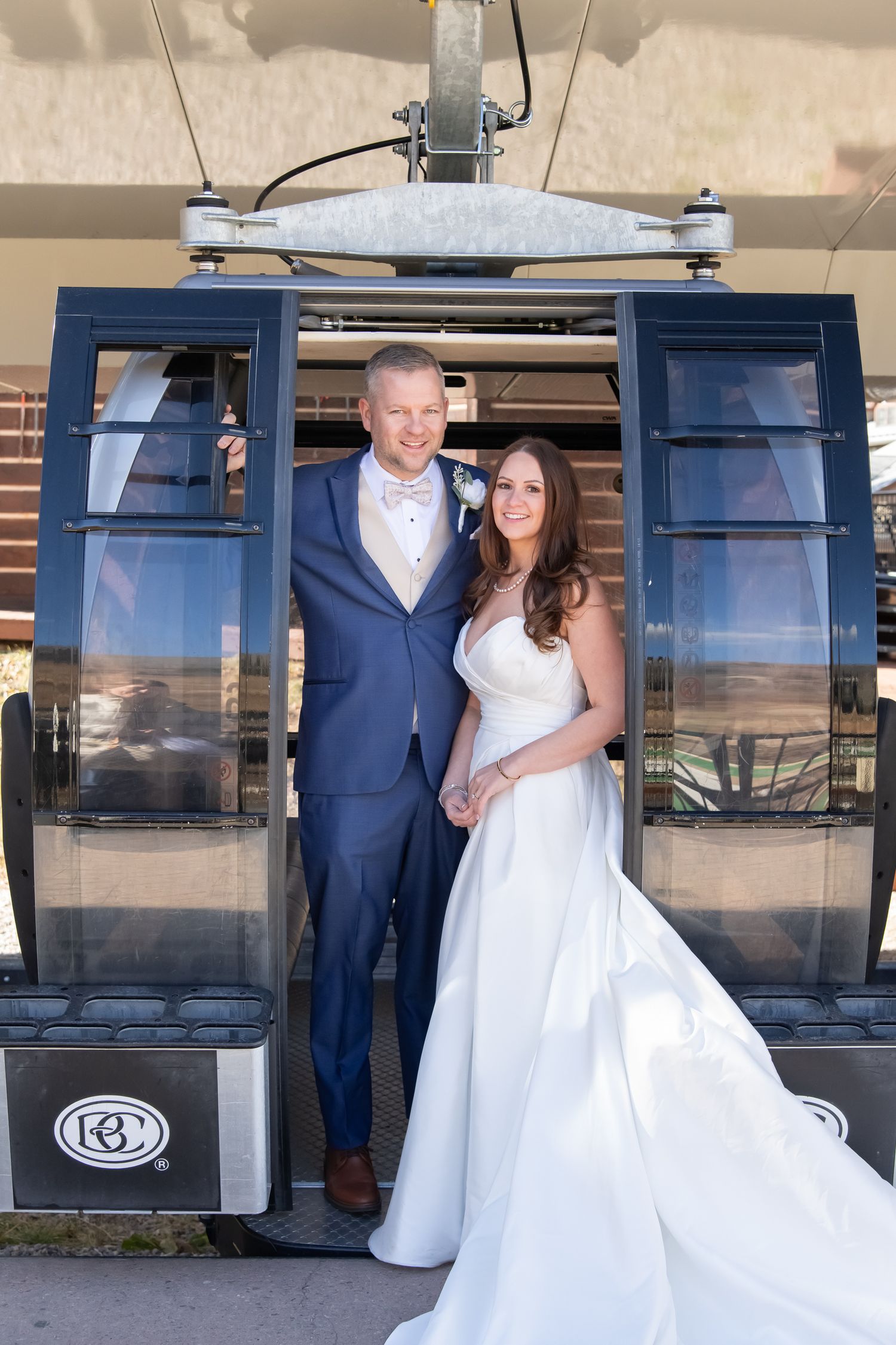 A wedding couple poses for photos in front of a ski lift gondola station in a sequence of romantic shots in Beaver Creek Colorado
