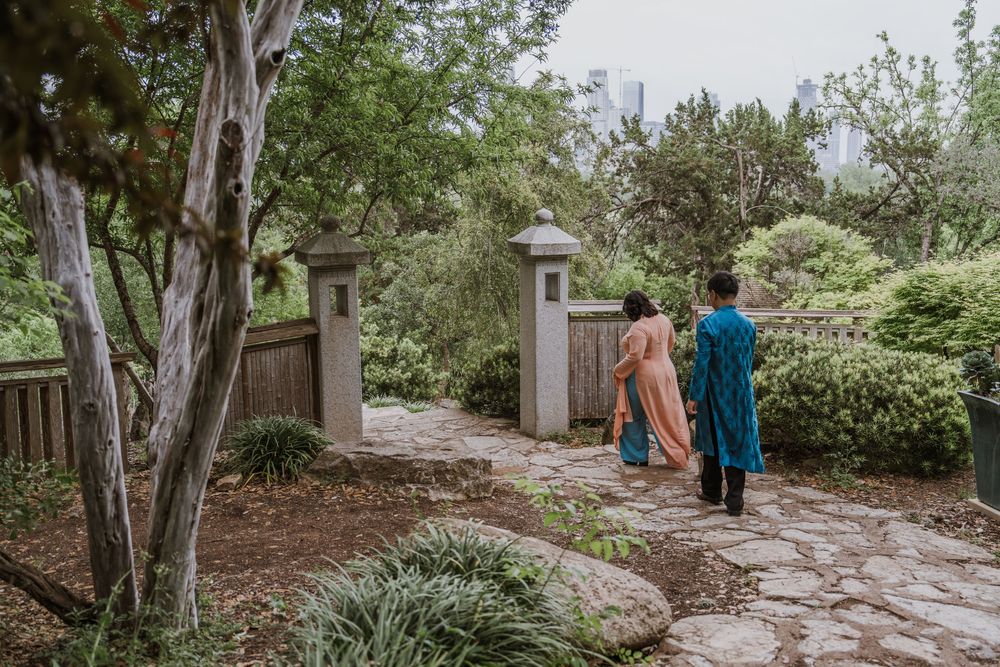 Tranquil garden walkway with stone columns and natural landscaping elements.