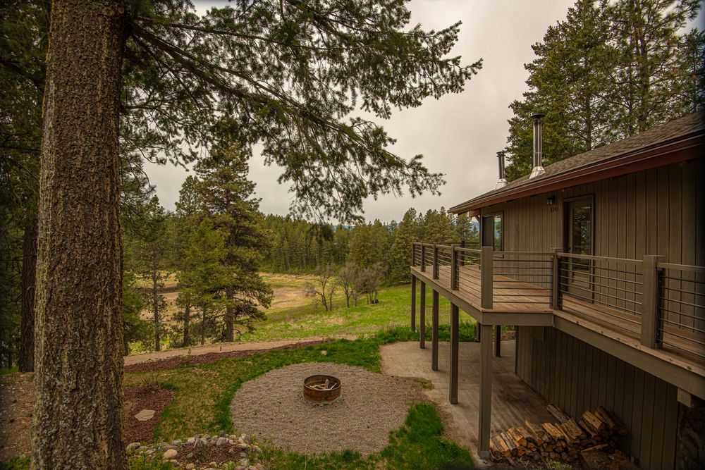 Scenic view of a rustic wooden cabin nestled among tall evergreen trees in a tranquil forest setting.