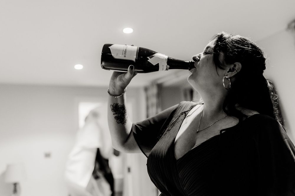 People drinking and toasting with champagne glasses in an indoor setting.