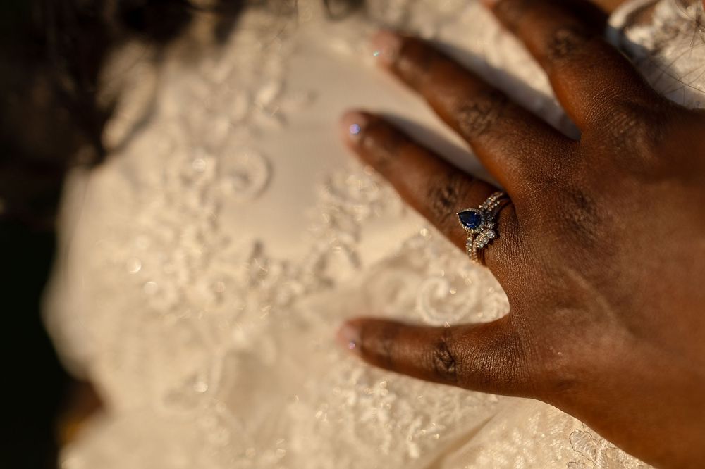 Close-up shots of hands wearing wedding rings and holding each other against a white lace background.