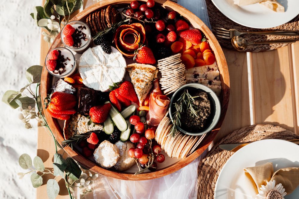 Overhead view of a rustic table setting with fresh berries, pastries, and coffee in warm morning light.