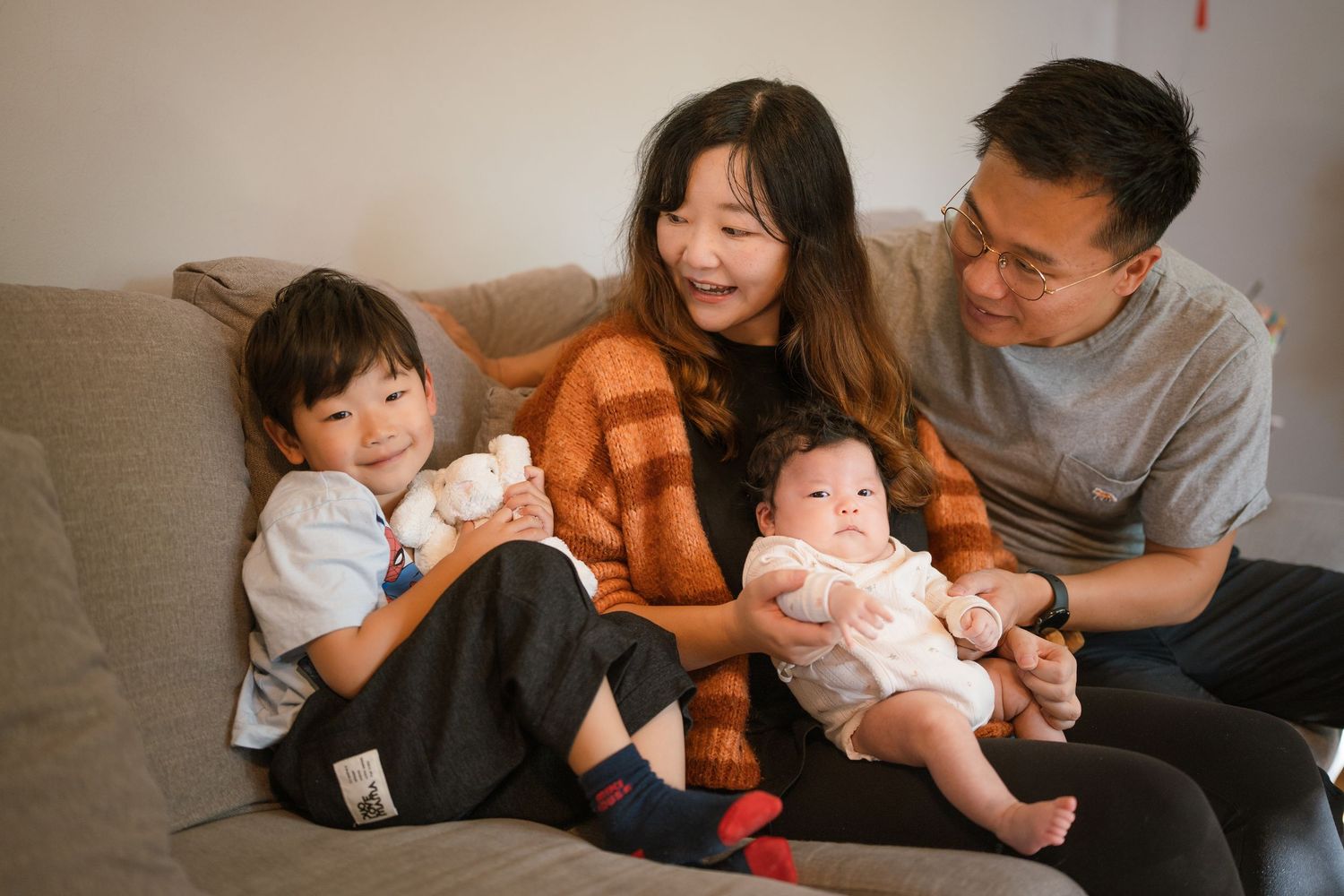 Family members share tender moments while relaxing together on a cozy couch at home.