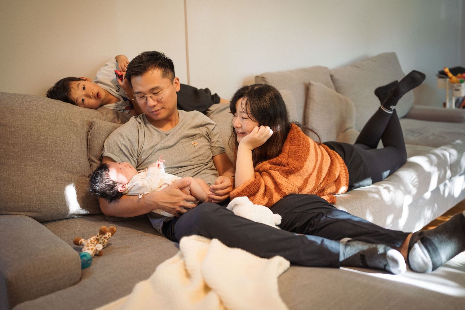 Tender family moments captured in a series of intimate photographs on a cozy couch.
