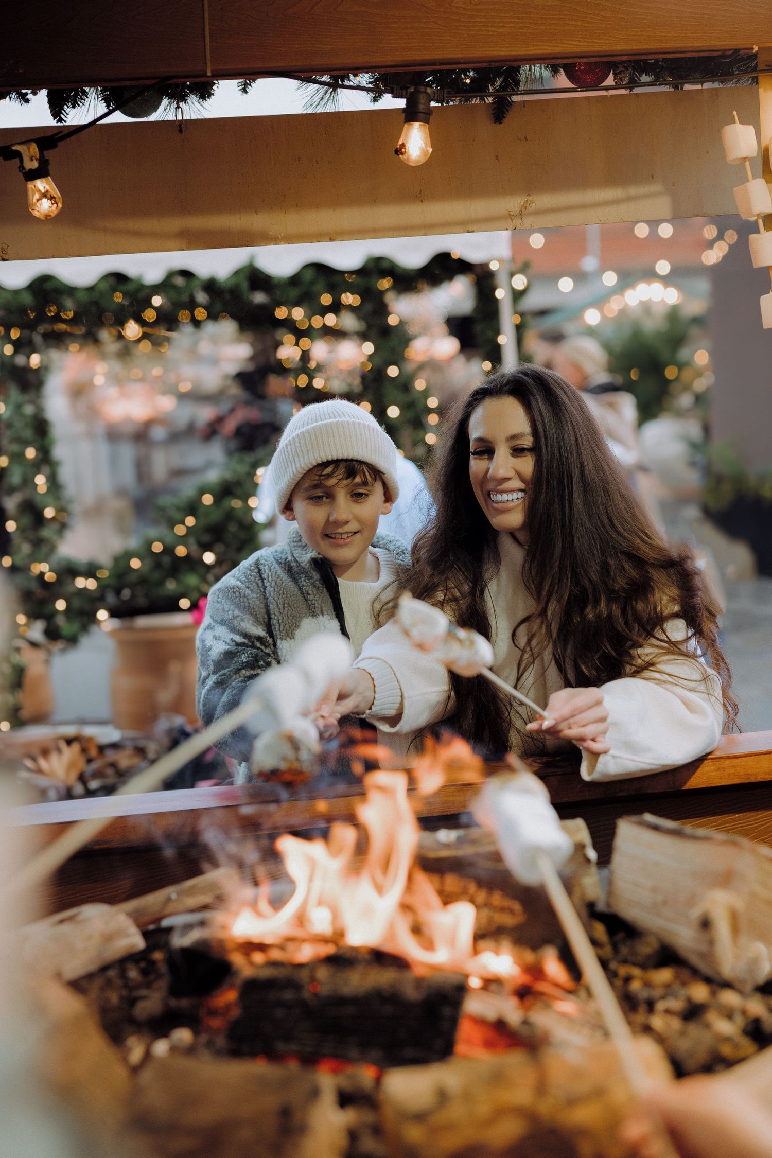 Romantic couple shares tender moments in front of a Christmas tree with twinkling lights and ornaments in the background.