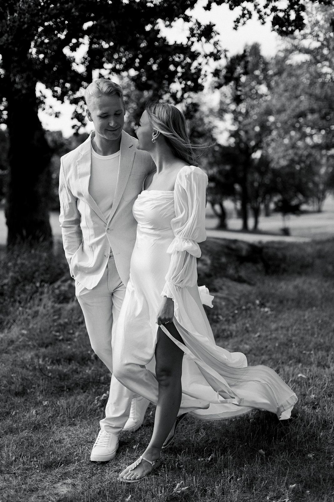 Black and white photo series of joyful moments captured in a grassy field on a sunny day.