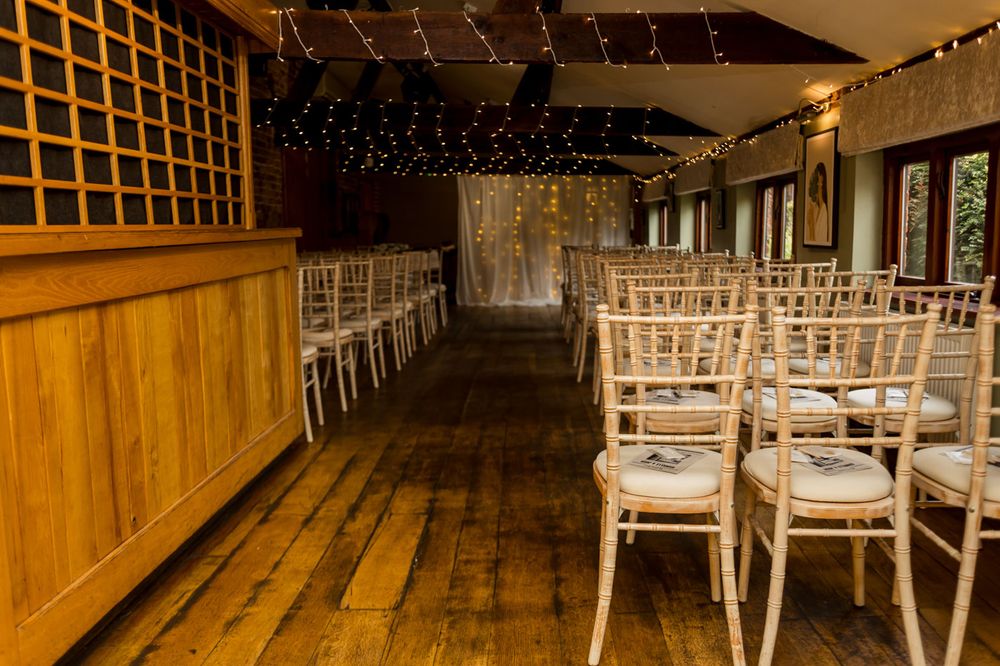 Wedding venue interior with white chairs and twinkling string lights creating a romantic atmosphere.