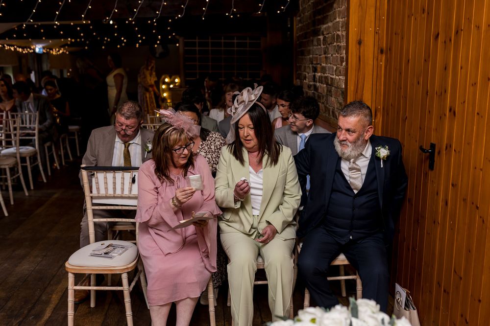 Wedding guests seated in rows watching an emotional ceremony moment.