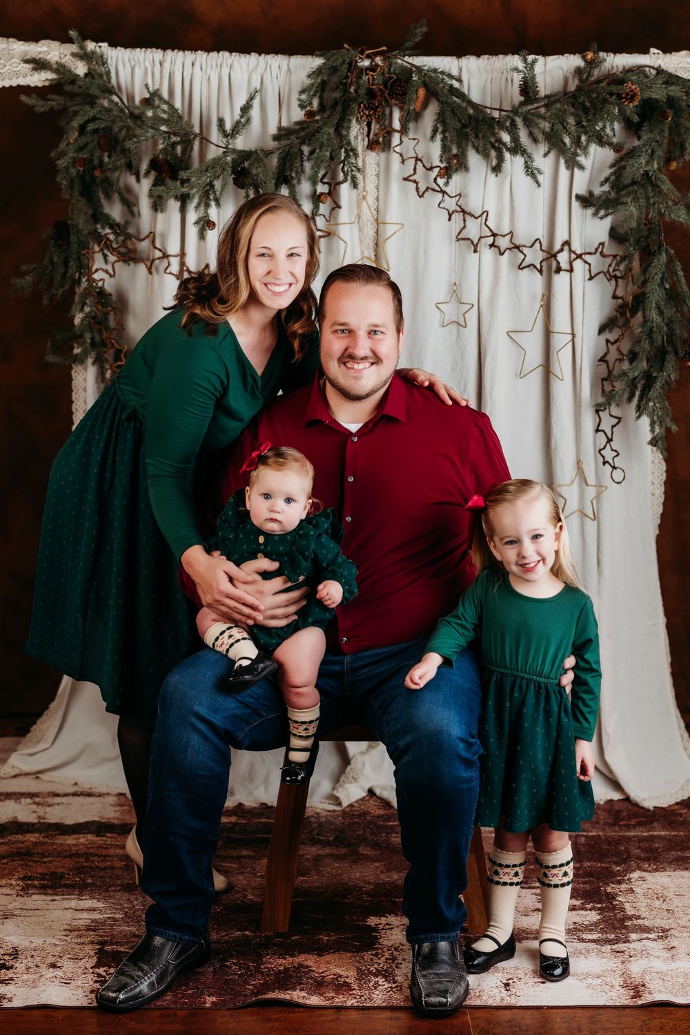 Family portrait series showing casual poses against white backdrop with star decorations and greenery.