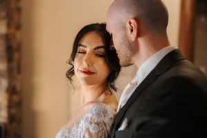 Close up shot of an elegant wedding couple sharing an intimate moment in warm lighting.