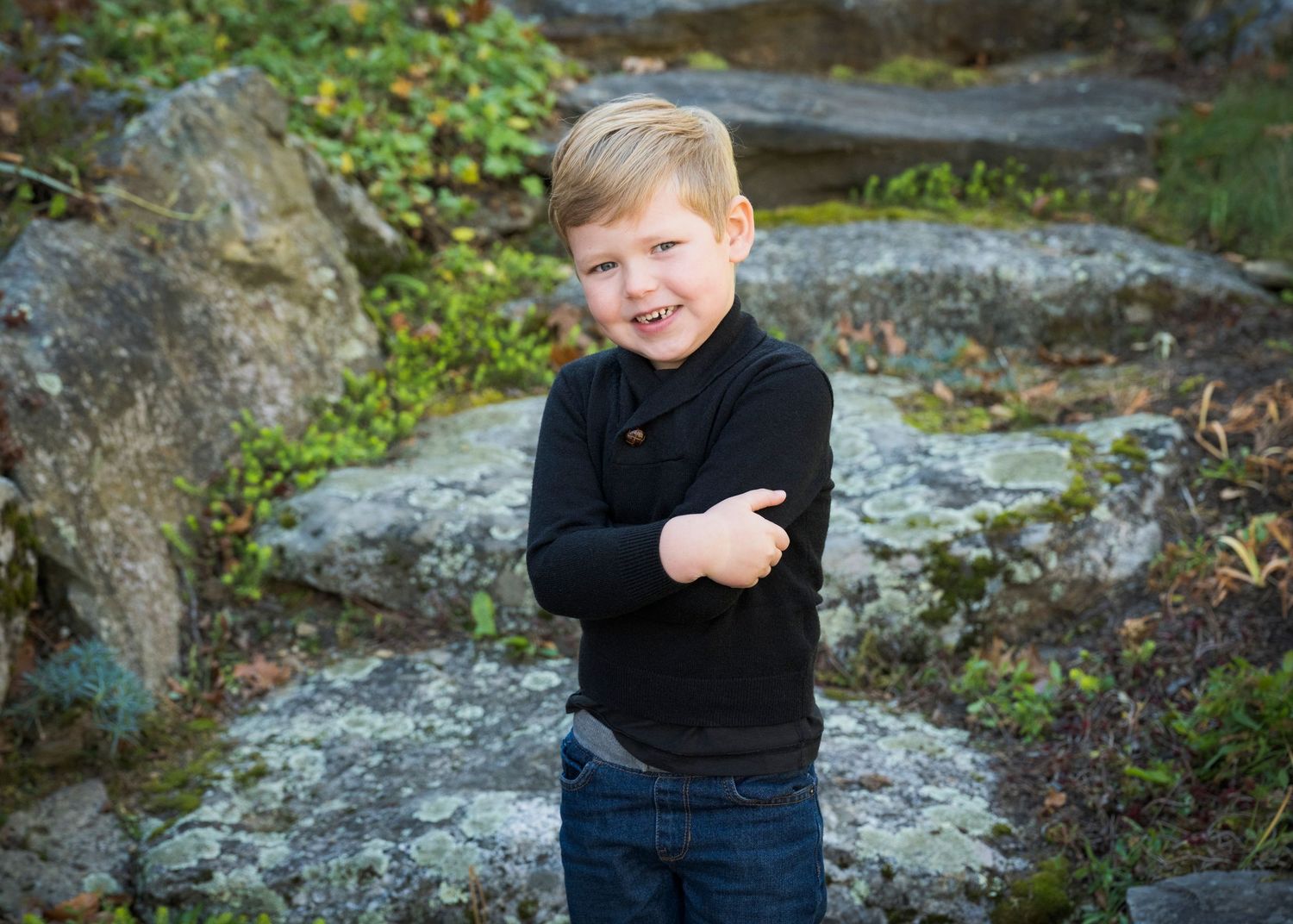 A series of candid outdoor photos showing someone in a black sweater posing on rocky terrain with greenery in background.