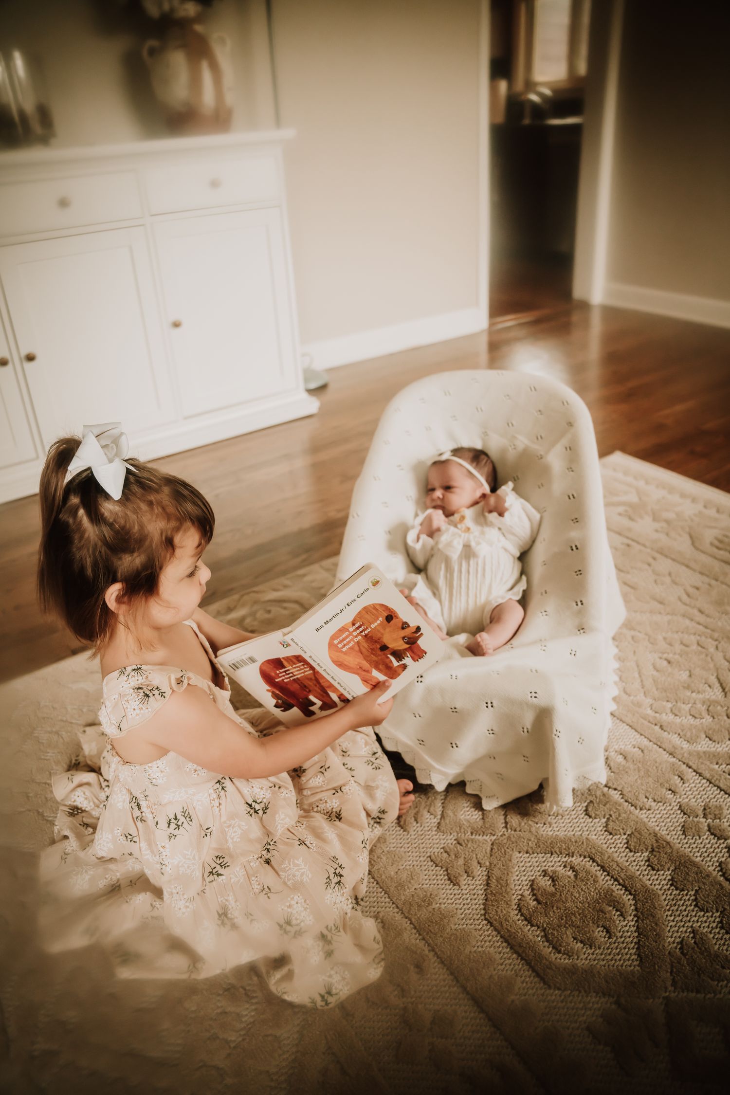 A girl reading to her newborn sister during a film session in Northbrook.